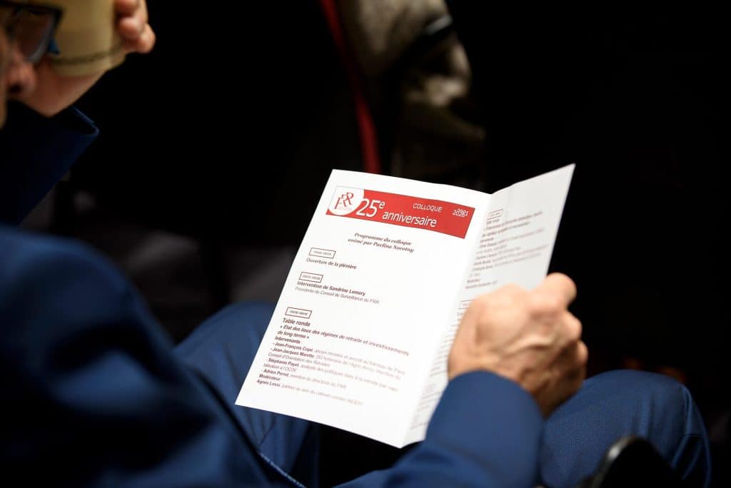 Un participant consulte le programme du colloque des 25 ans du FRR