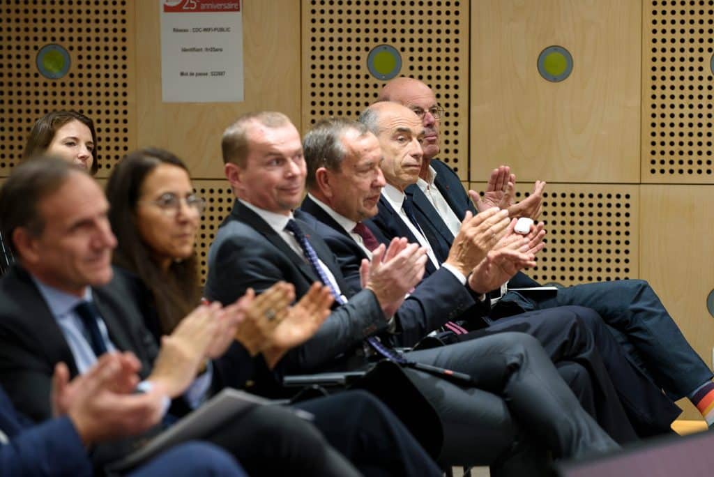 Des participants applaudissent au premier rang